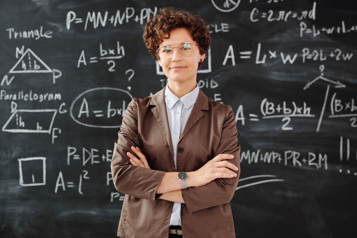 A teacher standing in front of a classroom board